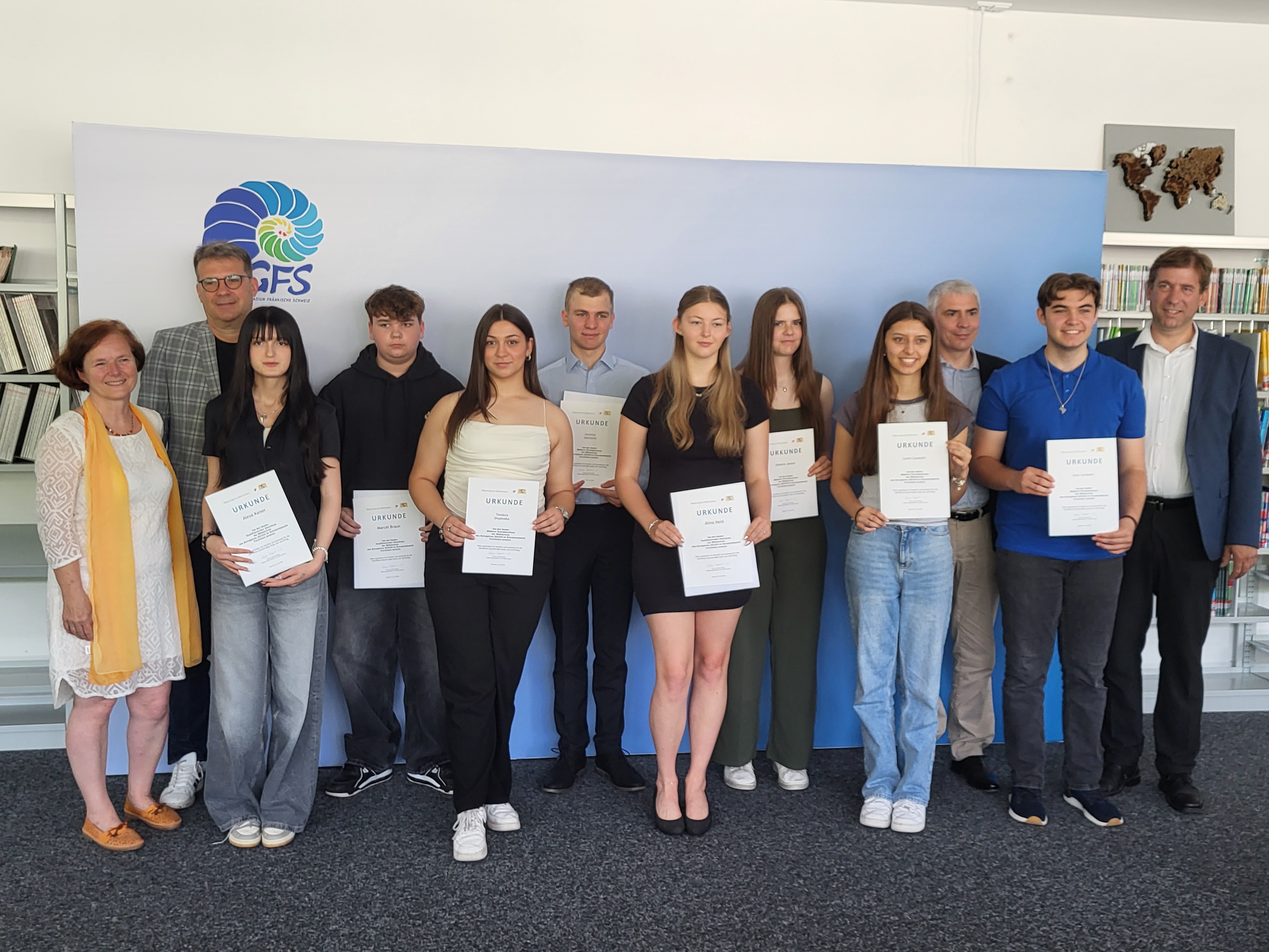 Ausgezeichnete Schüler mit zwei Lehrern zeigen ihre Urkunden