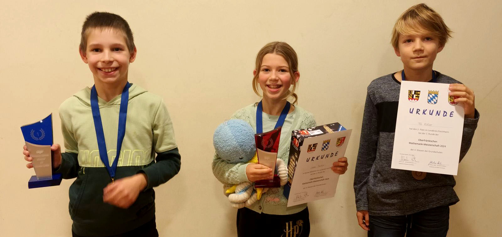 Schüler zeigen Preise und Urkunden zu "Mathematik macht Spaß"