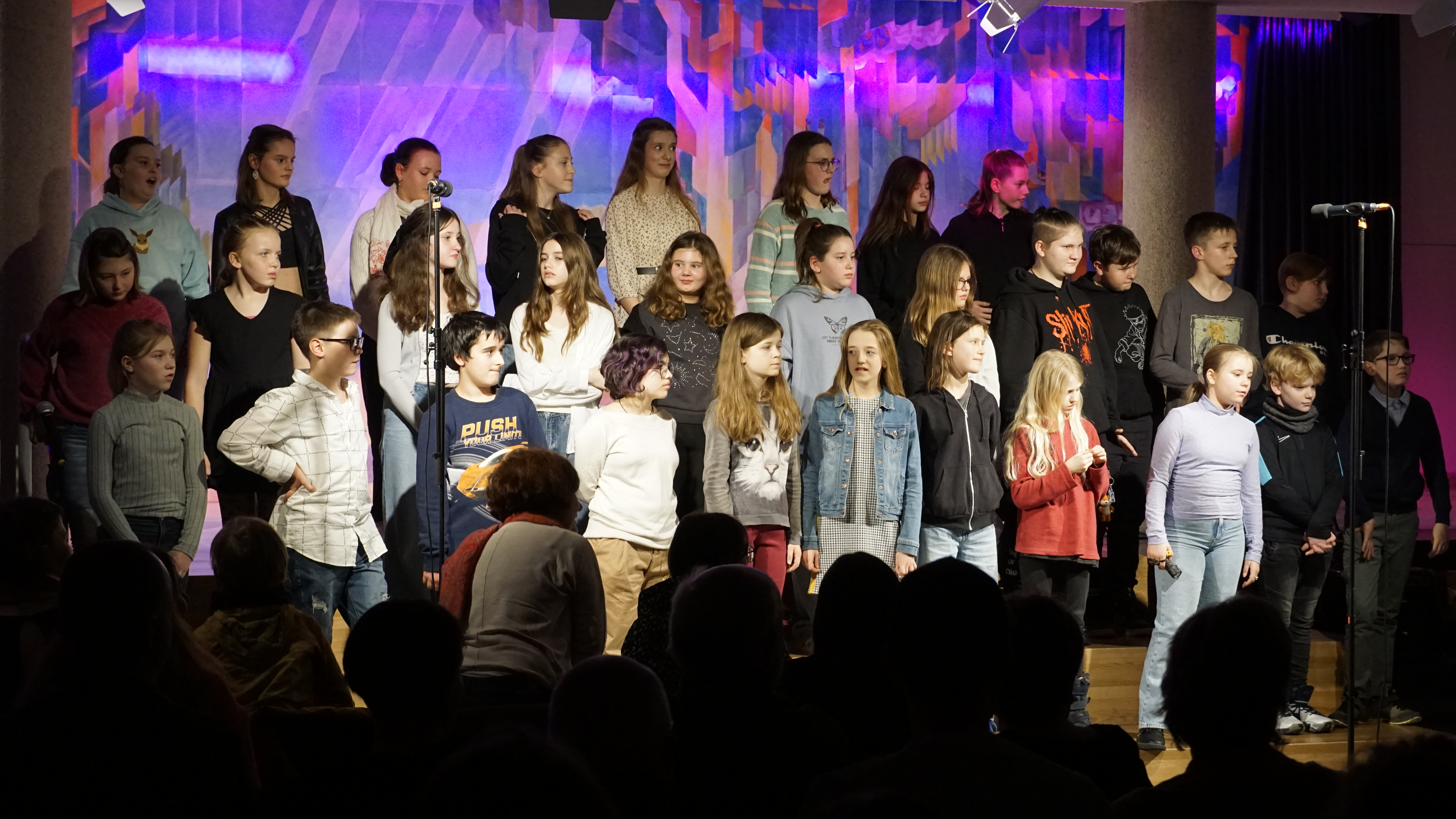 Schüler stehen auf einer Bühne und singen