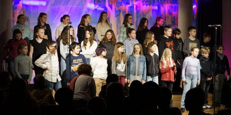 Schüler stehen auf einer Bühne und singen